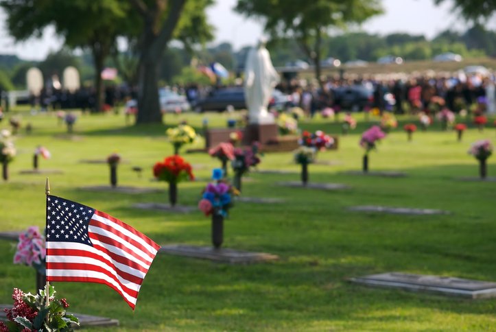 american-flag-and-flowers-at-cemetery-burial-service